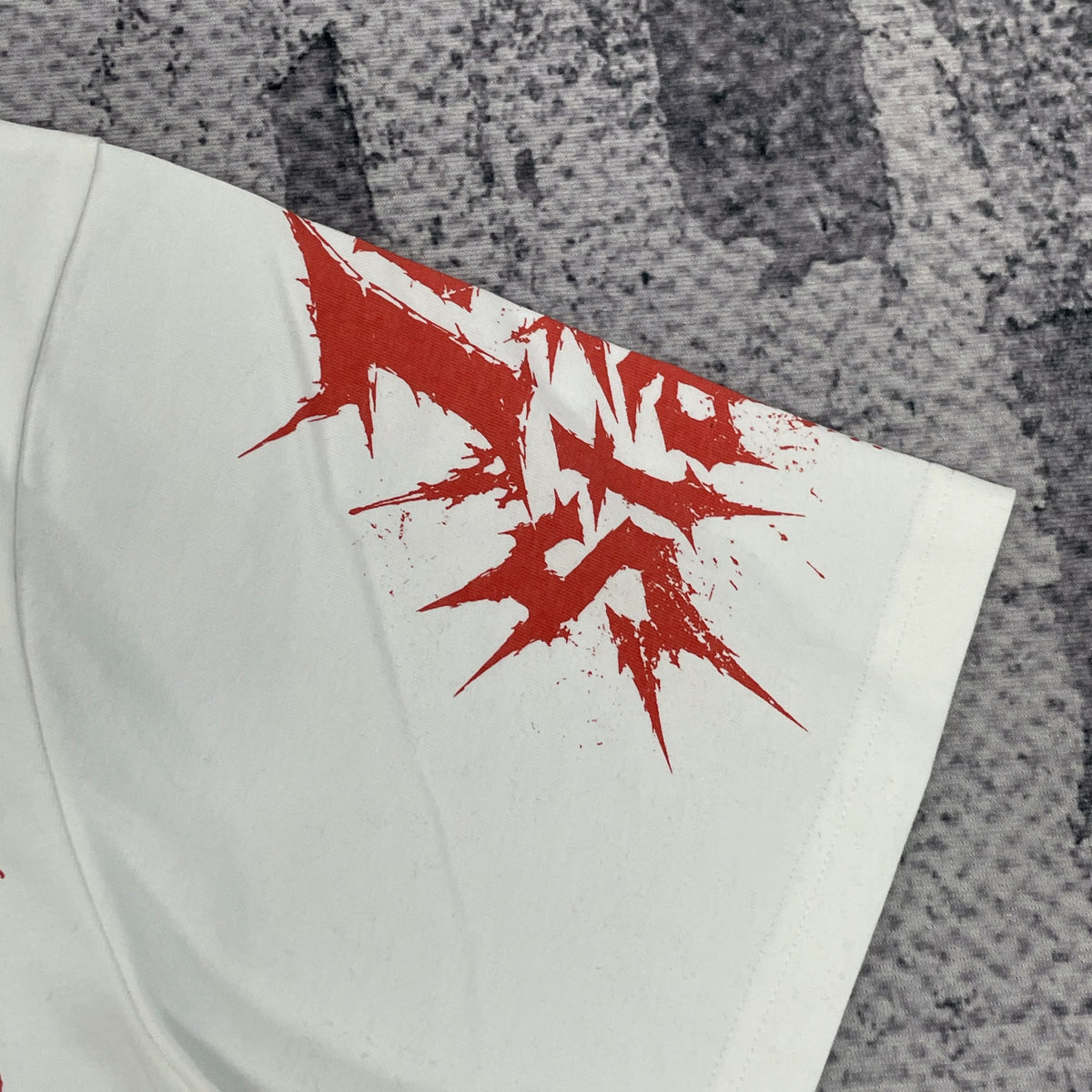 Close-up of red graphic on other white T-shirt sleeve